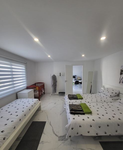 Bedroom with a double bed, single bed and baby cot