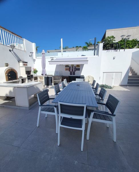 Outdoor dining table beside the outdoor kitchen with oven and barbecue