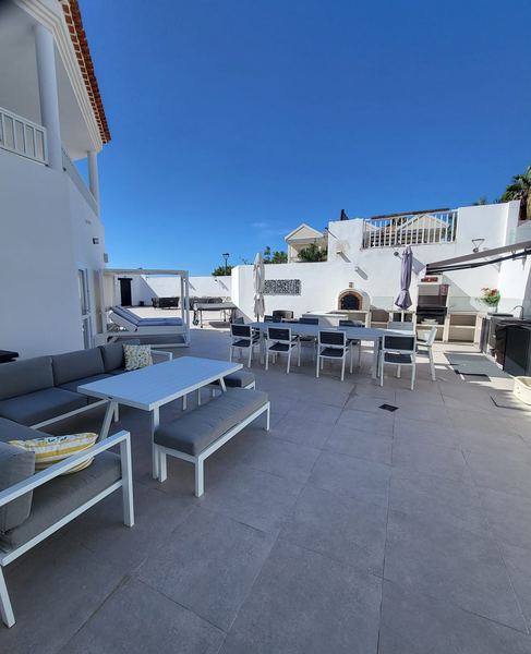 Large sunny terrace with outdoor lounge sofa, dining area and barbecue
