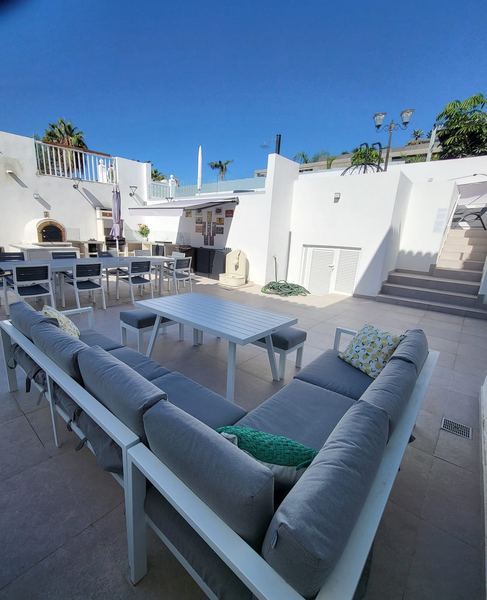 Terrace with outdoor lounge sofa, dining table and outdoor kitchen area
