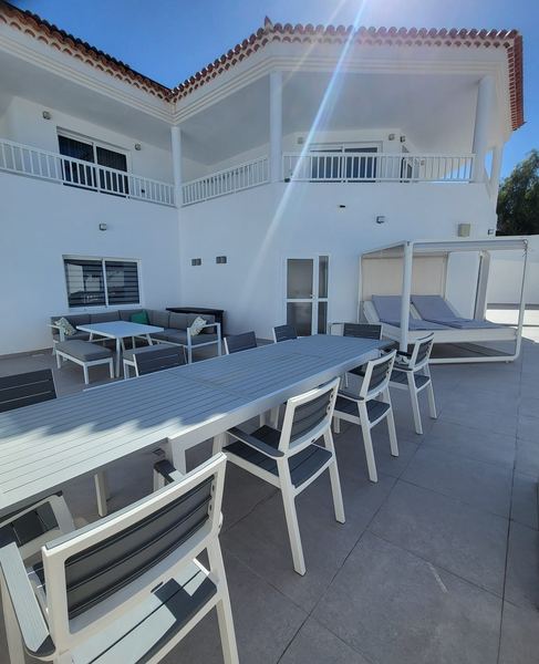 Villa exterior with terrace dining table and canopy daybed